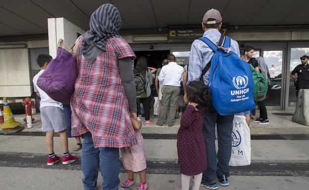 Refugiados sirios e iraquíes procedentes de Grecia hacen cola para recoger sus equipajes en Barajas, tras aterrizar en suelo español, el pasado mes de junio.