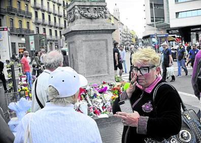 Imagen secundaria 1 - 1. A favor del sí. El dibujante Enric Pereda expone en su puesto caricaturas de los políticos protagonistas del 'procés'. 2. Conmovida. Irina Poliakova se enjuga las lágrimas ante las ofrendas en memoria de los atentados de agosto. 3. La estelada y la bandera española conviven en los quioscos. 