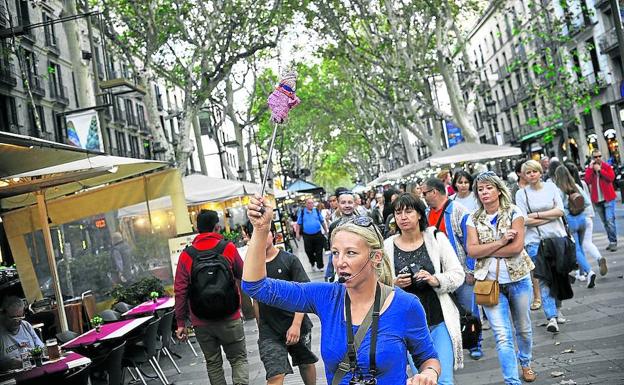 Turistas. Una guía encabeza un grupo de visitantes en su recorrido por las Ramblas.