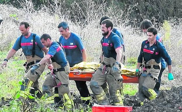 Equipos de emergencia trasladan uno de los cadáveres.