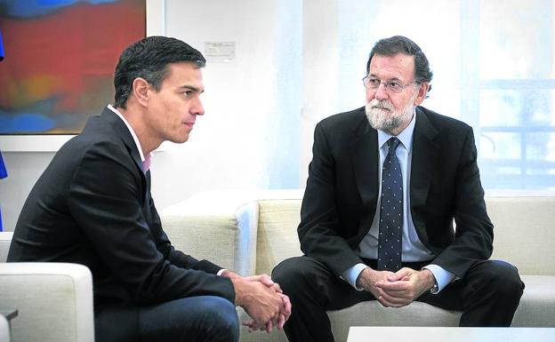El presidente del Gobierno recibe ayer al líder del PSOE, Pedro Sánchez, a su llegada al Palacio de La Moncloa.