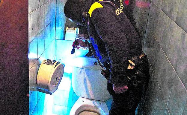 Un policía local registra los baños de un bar de Vitoria. 