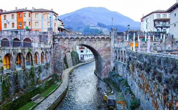 Imagen principal - Puente medieval sobre el río Quiviesa, en Potes. El autor de este reportaje (en el centro), durante el recorrido. El ‘Lignum Crucis’ preside el interior del santuario.