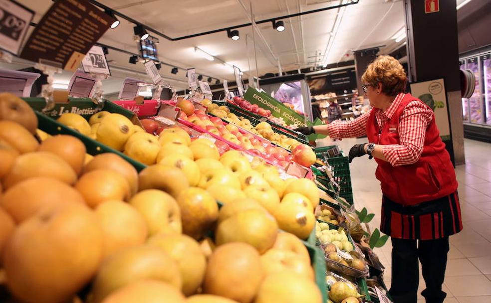 Una trabajadora repone el género en un supermercado.