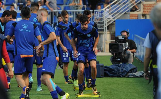 Los jugadores del Alavés calientan sobre el césped de Mendizorroza.