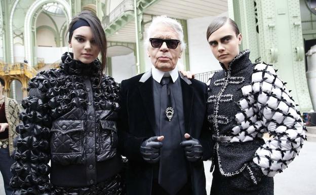 El modisto Karl Lagerfeld, escoltado por las modelos Kendall Jenner (izq.) y Cara Delevigne (der.). 