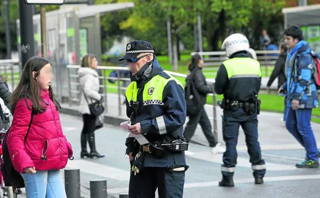 Un agente local se dispone a multar a una adolescente, en la tarde de ayer en la calle Magdalena. 