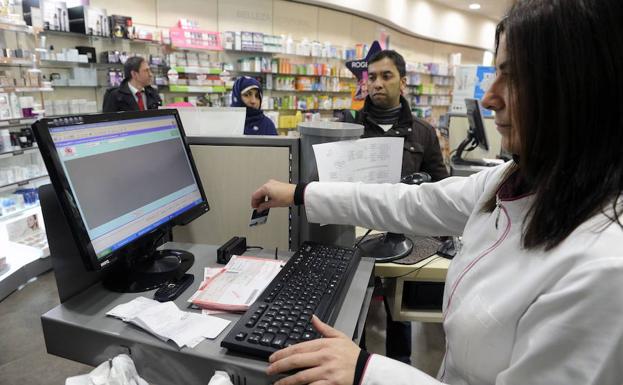 Una farmacéutica cobra unos medicamentos en un establecimiento de Bilbao. 