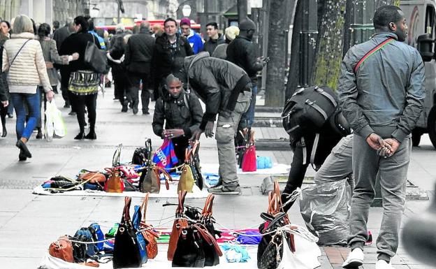 Manteros exponen su mercancía en la Gran Vía bilbaína.