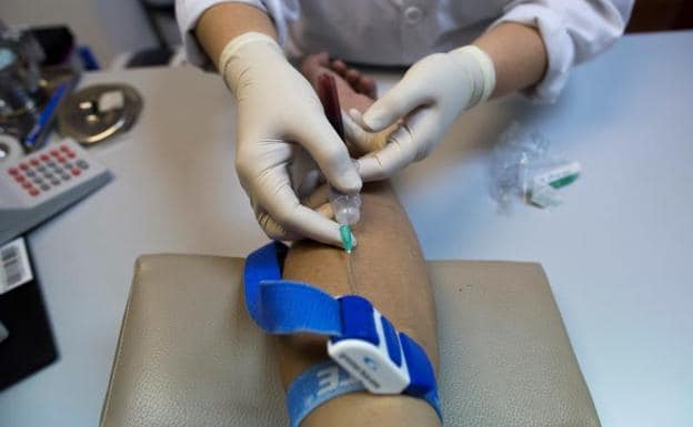 Una enfermera toma una muestra de sangre para una prueba del VIH.