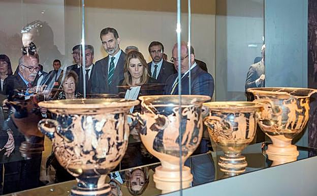 El rey Felipe VI , acompañado de la presidenta de la Junta de Andalucía, Susana Díaz, observa unas crateras que forman parte de la exposición temporal "La Dama, el Príncipe, el Héroe y la Diosa", con la que se ha inaugurado el Museo Íbero de Jaén