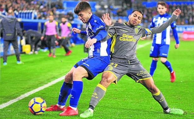 Martín protege el balón con el cuerpo ante la presión del jugador de Las Palmas Jonathan Viera, en el último partido disputado en Mendizorroza. 