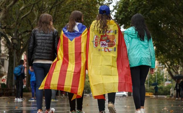 Jóvenes con banderas caminar por una calle de Barcelona.