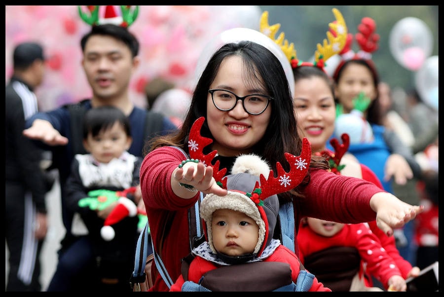 Madres con sus bebés se presentan durante un baile navideño en el centro de Hanoi. Las navidades no son una fiesta oficial en Vietnam. Sin embargo, algunas de sus costumbres se han vuelto más populares en los últimos años