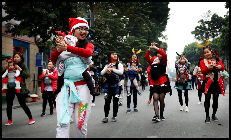 Madres con sus bebés se presentan durante un baile navideño en el centro de Hanoi. Las navidades no son una fiesta oficial en Vietnam. Sin embargo, algunas de sus costumbres se han vuelto más populares en los últimos años