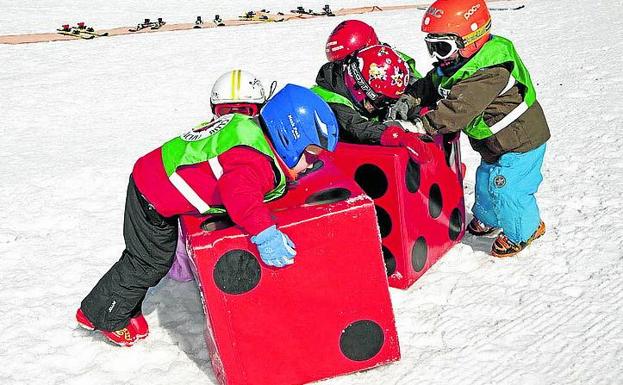 Imagen principal - Un grupo de niños juega en Candanchú, un tiro de perros en Baqueira y telesillas que conducen a los deportistas a las pistas de Masella.