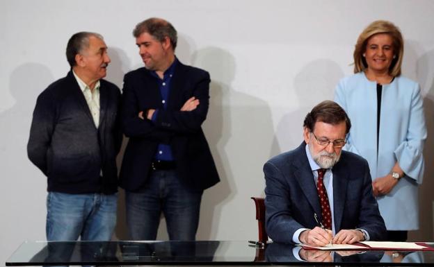 Rajoy, acompañado por la ministra de Empleo, Fátima Báñez, y los secretarios generales de UGT y CCOO, Pepe Álvarez y Unai Sordo, en la firma para la subida del salario mínimo interprofesional.
