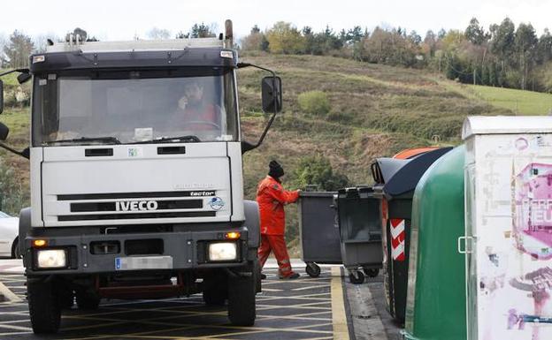 Operarios retiran la basura de los contenedores en Mendexa. 