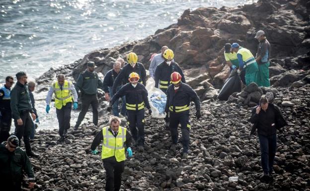 Efectivos de los servicios de emergencias trasladan el cuerpo de uno de los fallecidos en la playa Bastián de Costa Teguise.