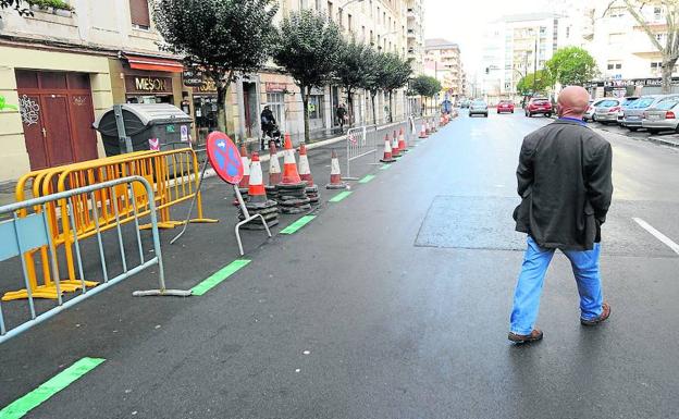 Un hombre pasa junto a las vallas y conos colocados en un lateral de la calle Florida.