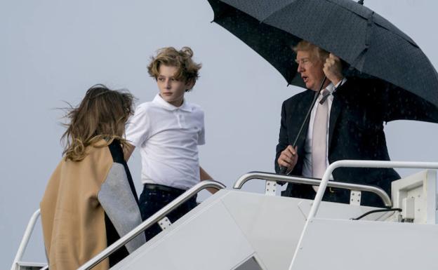 Trump se tapa y su mujer e hijo se mojan.