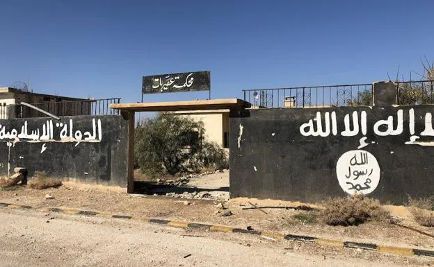 Imagen principal - En Aqerbat no ha habido tiempo de destruir los símbolos del califato, ni de borrar las banderas y eslóganes de los tres años de dominio yihadista.