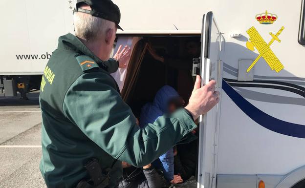 Un efectivo de la Guardia Civil descubre a uno de los inmigrantes.