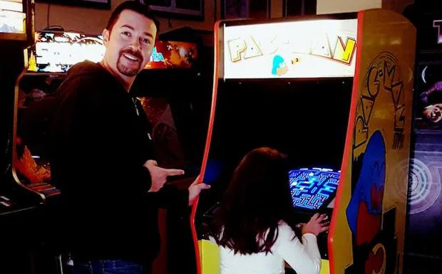 José María Litarte señala a su hija mientras juega al ‘Pac Man’ o ‘comecocos’