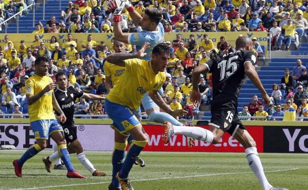 El portero argentino de la UD Las Palmas, Leandro Chichizola (c), para un balón ante el Sevilla.