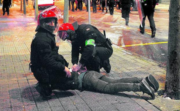 Inmovilizado. Dos ertzainas esposan a uno de los radicales al lado de San Mamés. 