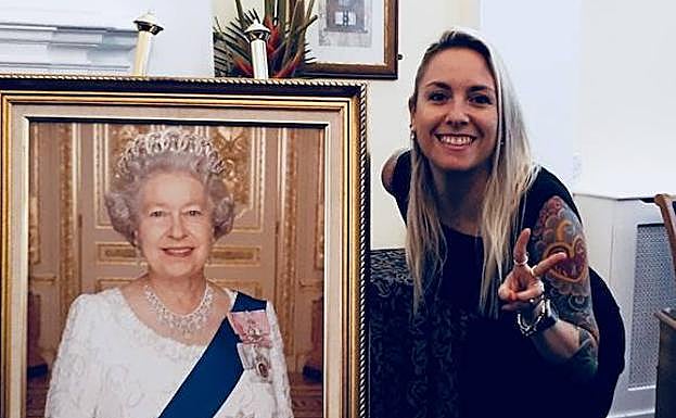 La valenciana Lorena Obón posa junto al retrato de la reina Isabel al recibir la nacionalidad británica.
