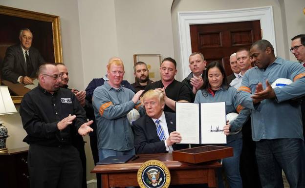 Donald Trump, rodeado ayer de trabajadores del metal, tras firmar la imposición de aranceles.