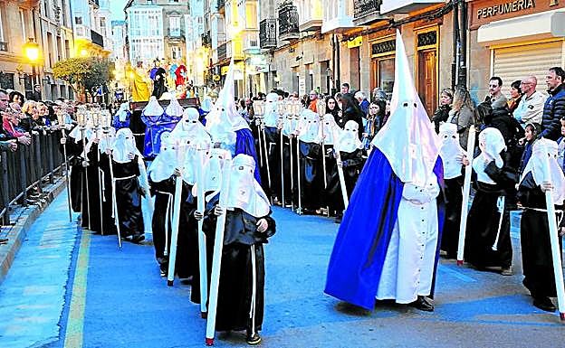 El cuerpo de nazarenos alumbra el camino al paso a la procesión de la Cena del Señor, que recorre las calles de Haro la noche del Jueves Santo.