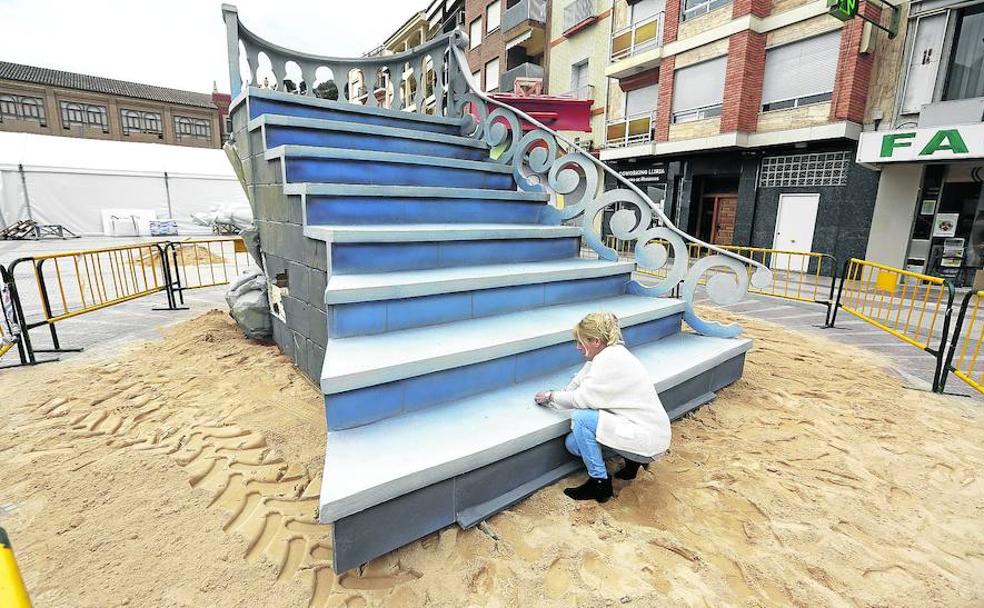 Una fallera reparaba el miércoles un boquete en la escalera, una de las piezas de la falla.