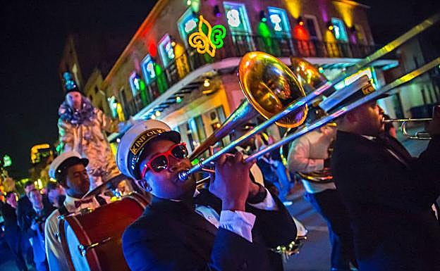 Una orquesta callejera, de ronda nocturna por el Barrio Francés de Nueva Orleans, famoso por sus balcones de hierro forjado, legado de su pasado español.
