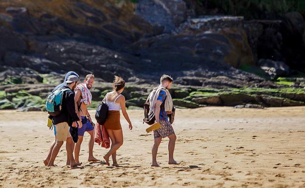 Un grupo de amigos se dispone a tender las toallas en la playa de Laidatxu, en Mundaka.