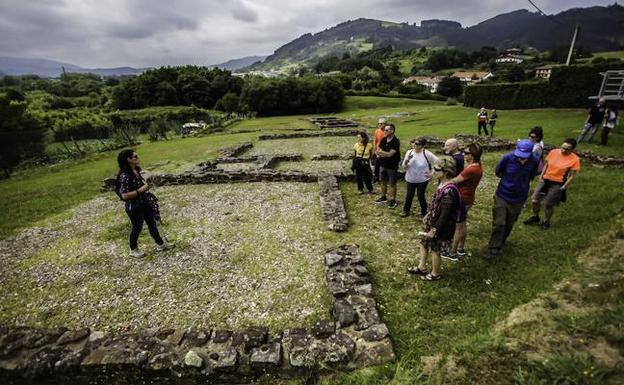 Turistas visitan el poblado romano de Forua. 