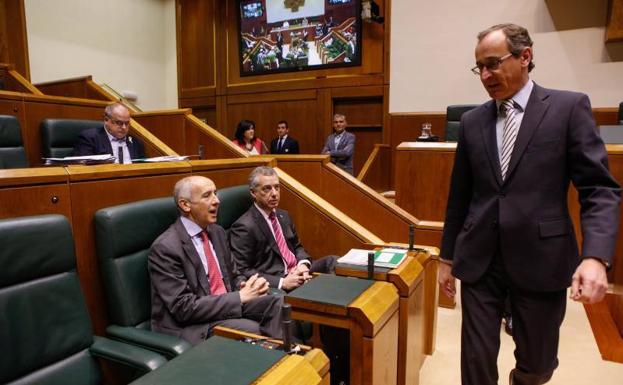 Alfonso Alonso (PP) pasa por delante del lehendakari y Josu Erkoreka (PNV) durante el pleno de hoy. 