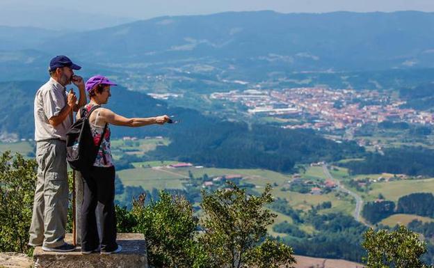 Visitantes contemplan Urdaibai desde San Miguel de Ereñozar. 