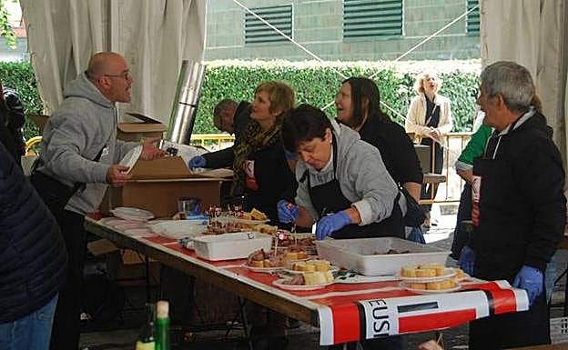 Los organizadores preparan los pitxos de ternera asada para su venta al público. 