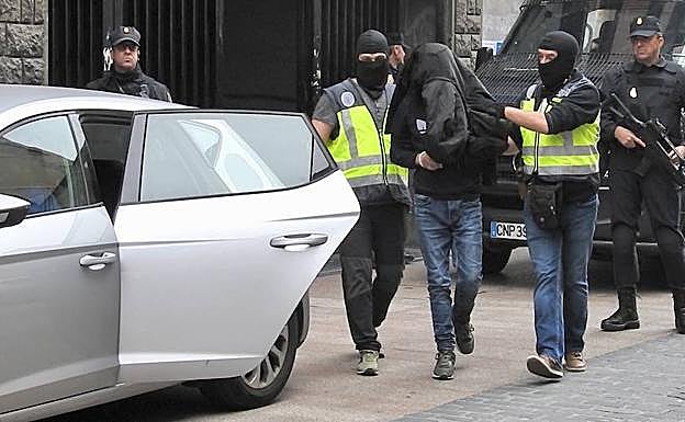 El arrestado es trasladado por la Policía Nacional. 