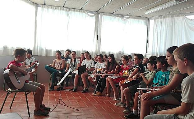 Alumnos de Primaria del Instituto Escuela Artística Oriol Martorell, centro integrado de Música en Barcelona, escuchan la ejecución de uno de sus compañeros mientras esperan su turno.