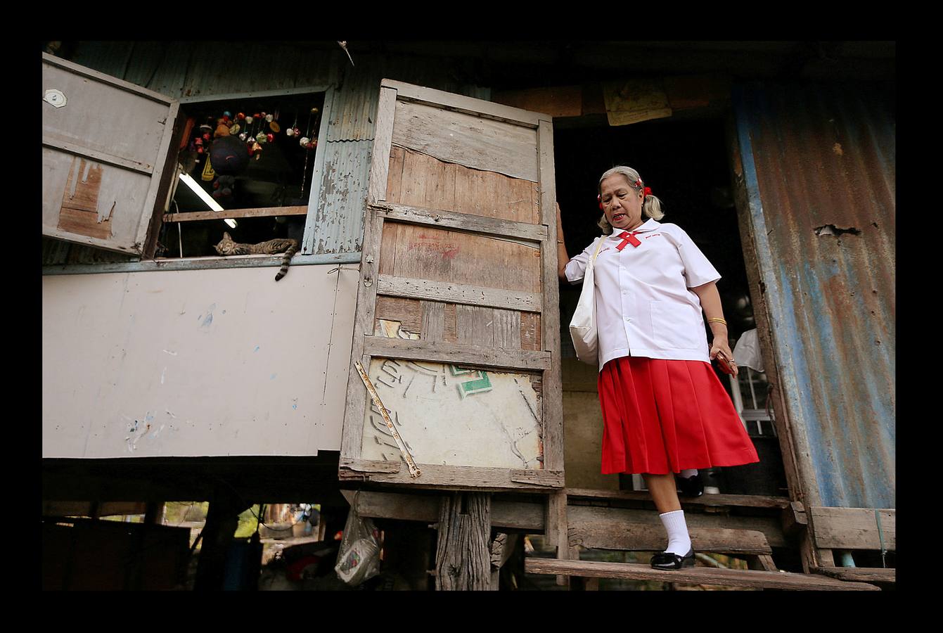 Un grupo de sexagenarias, con uniformes rojos y blancos, sonríen en el autobús que les conduce a la escuela. En Ayutthaya, una provincia de Tailandia, el país que envejece más rápido junto con China, hace no mucho tiempo los ancianos vivían con sus familias y eran cuidados por sus hijos. Pero el progresivo abandono del campo para trabajar en las ciudades ha hecho crecer el número de mayores que viven solos. Escuelas como la de Ayutthaya, ubicada 80 kilómetros al norte de Bangkok, que ofrecen clases semanales durante tres meses, son la manera como el gobierno proporciona alivio a la envejecida población contra el estrés de vivir solos.