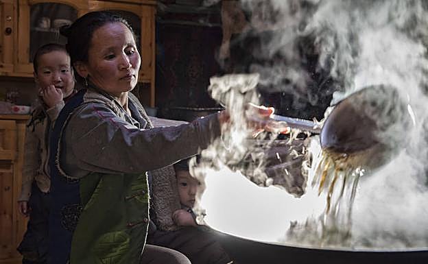 Davaasuren prepara un guiso ante la mirada de sus nietos.