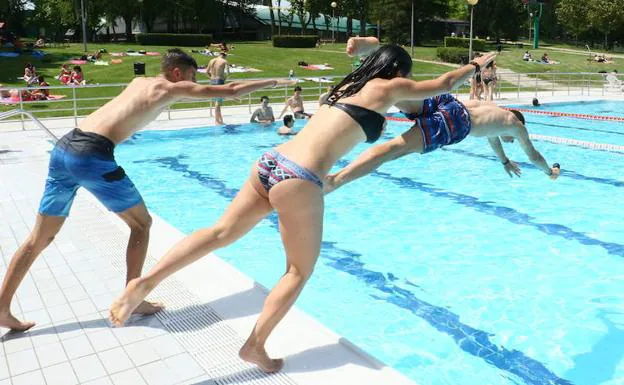 Un grupo de jóvenes se dispone a lanzarse a una piscina en Mendizorroza.