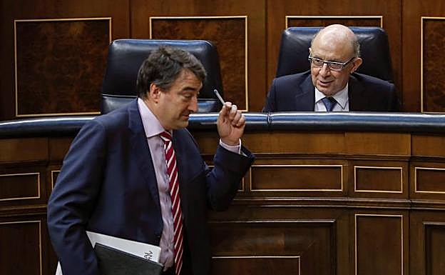 El ministro de Hacienda, Cristóbal Montoro, conversa con el portavoz del PNV, Aitor Esteban, durante el Pleno del Congreso.