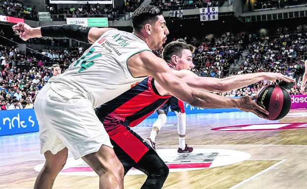 Matt Janning protege el balón de los largos brazos de Ayón.