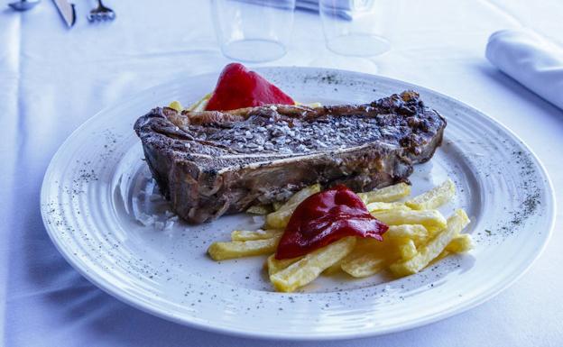 Chuletón con patatas y pimientos.