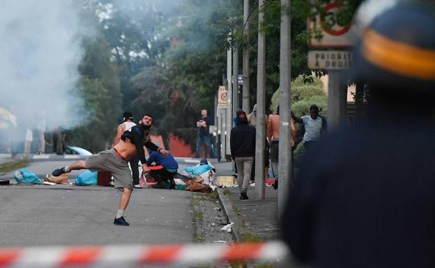 Un joven lanza piedras contra la Policía.