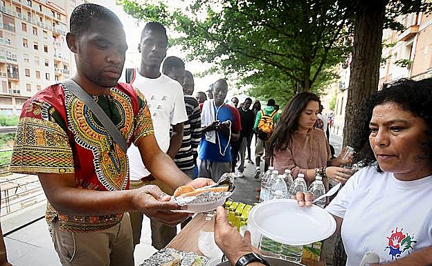 Miembros de la plataforma ciudadana Ongi Etorri Errefuxiatuak dan de comer a varios migrantes en Bilbao.
